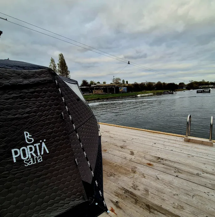 A mobile sauna pitched at the water's edge