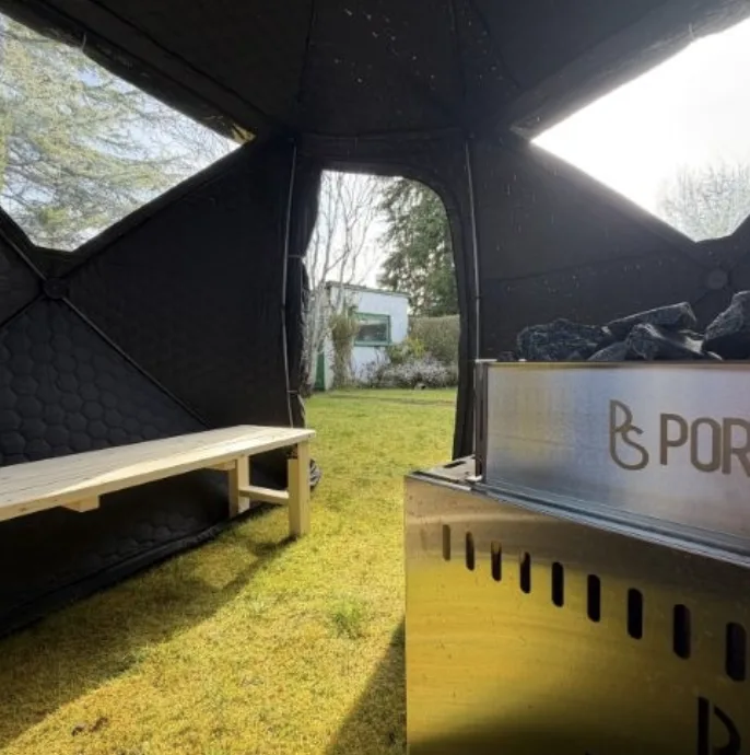 Inside a mobile sauna, bench and wood-fired stove ready to go